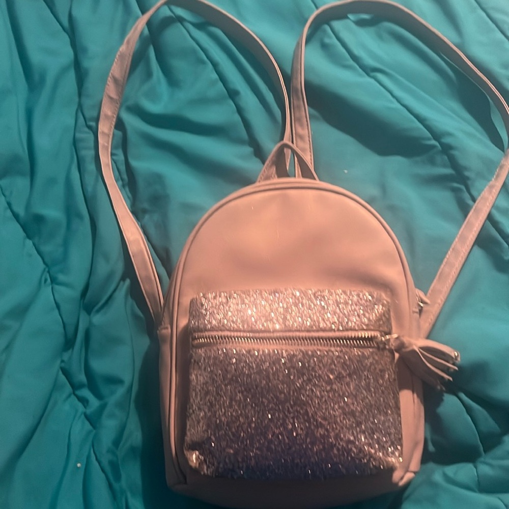 Purple mini backpack with front sparkly pocket. Inner pocket & adjustable straps